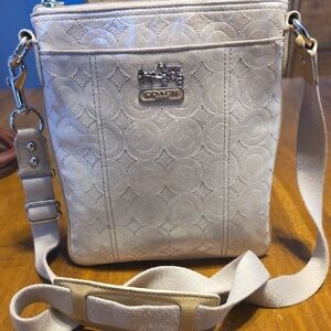 Coach pearlescent shimmer signature C embossed leather crossbody bag.